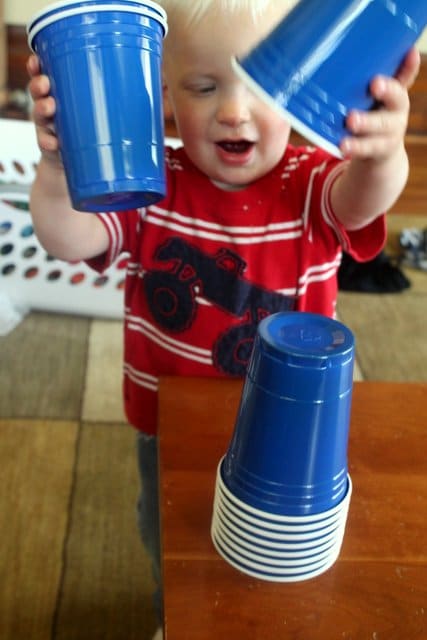 Toddler playing with plastic cups