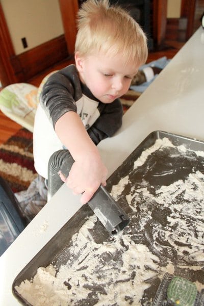 Suck up the flour sensory play with a vacuum to make cleaning fun for kids!