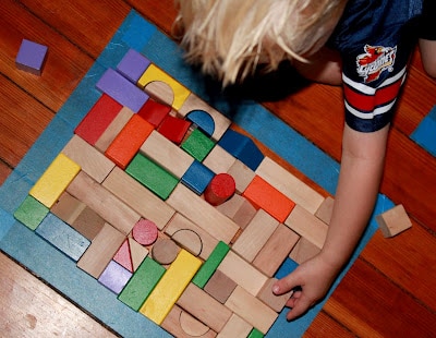 Make a puzzle on the floor with a simple shape and fill it in with blocks.