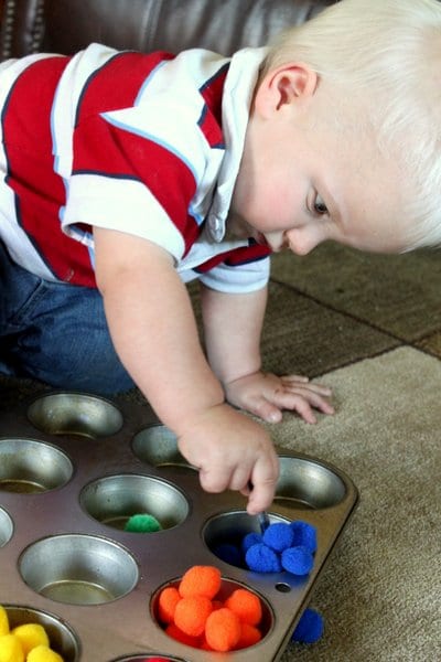 We love simple fine motor play by sorting pom poms for toddlers