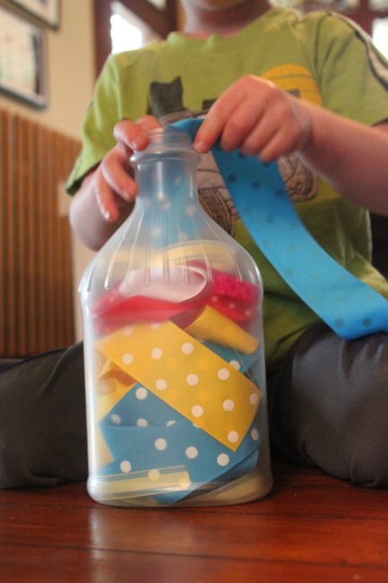 Ribbons. Add a bottle to the mix with ribbons. Let your child work on fine motor skills by pushing ribbons in and out of the bottle.