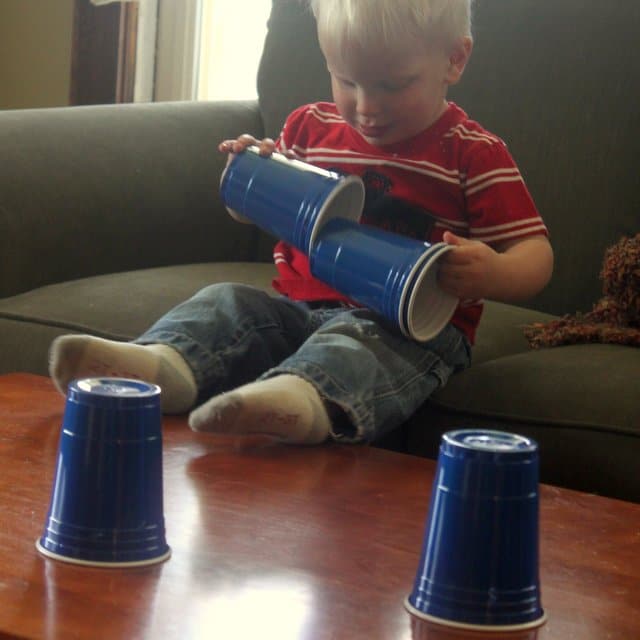 Toddler playing with plastic cups