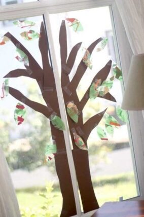 Paper tree taped to a window with colorful paper leaves