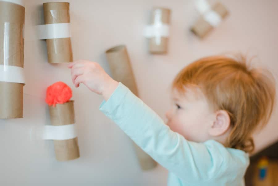 Simple is key with toddlers and this pom pom drop activity is perfect to keep them occupied with many bonus benefits!