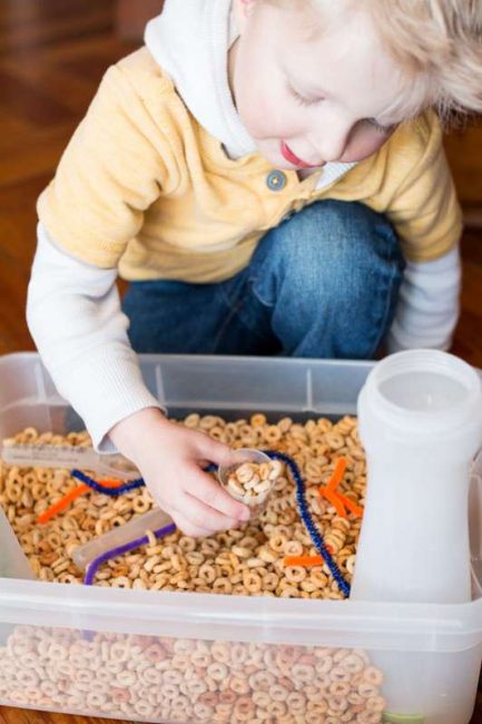 A simple cereal sensory bin for toddlers with threading activity 