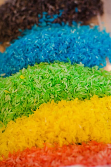 A rainbow rice sensory bin is great for toddlers! Learn how to make colored rice like this.
