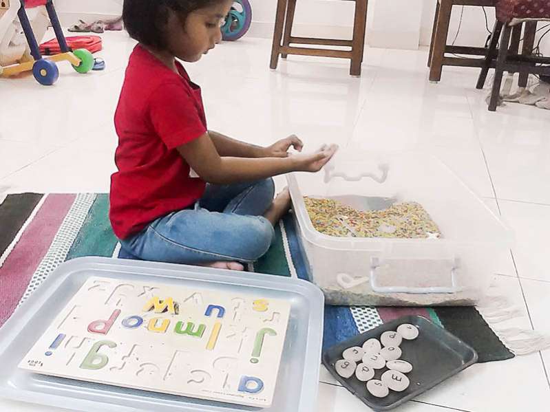 Matching letters in a rainbow rice sensory bin