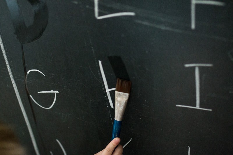 Write letters and numbers on a chalkboard to trace and erase them away