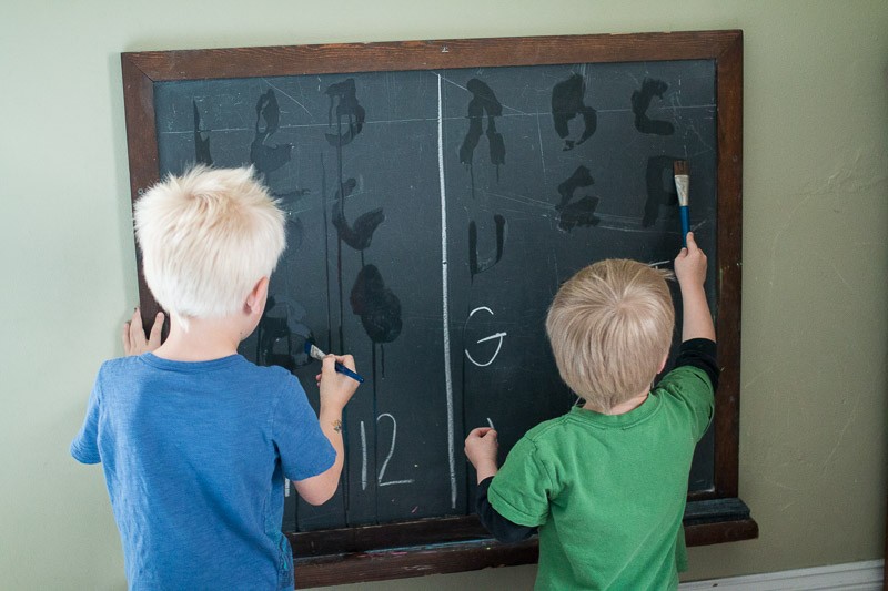 Write letters and numbers on a chalkboard to trace and erase them away
