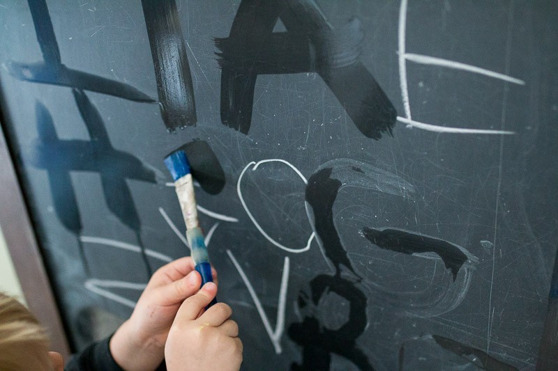 Preschoolers can take lead and write letters on the chalkboard for younger kids to trace and erase away