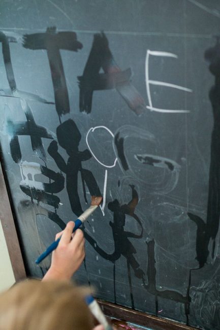 Preschoolers can take lead and write letters on the chalkboard for younger kids to trace and erase away