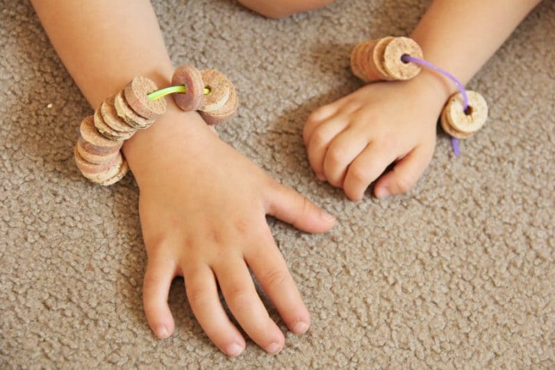 Cork bead bracelets can help kids develop and build fine motor skills like threading.