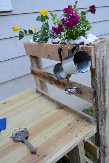 Use nails or hooks to hang cooking utensils on the mud kitchen