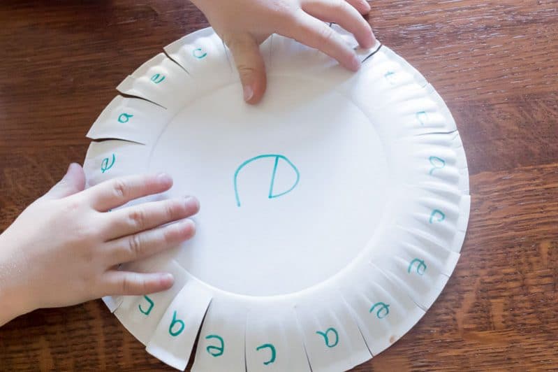 Using a paper plate to practice learning a couple of letters -- so smart!