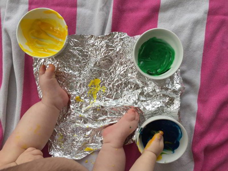 This baby foil painting art activity is messy, but so much fun! Learn how to make instant edible finger paint that's safe for your baby.
