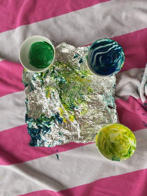 This baby foil painting art activity is messy, but so much fun! Learn how to make instant edible finger paint that's safe for your baby.