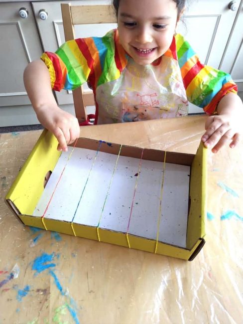 Your preschooler will love creating beautiful artwork with rubber bands and paint!