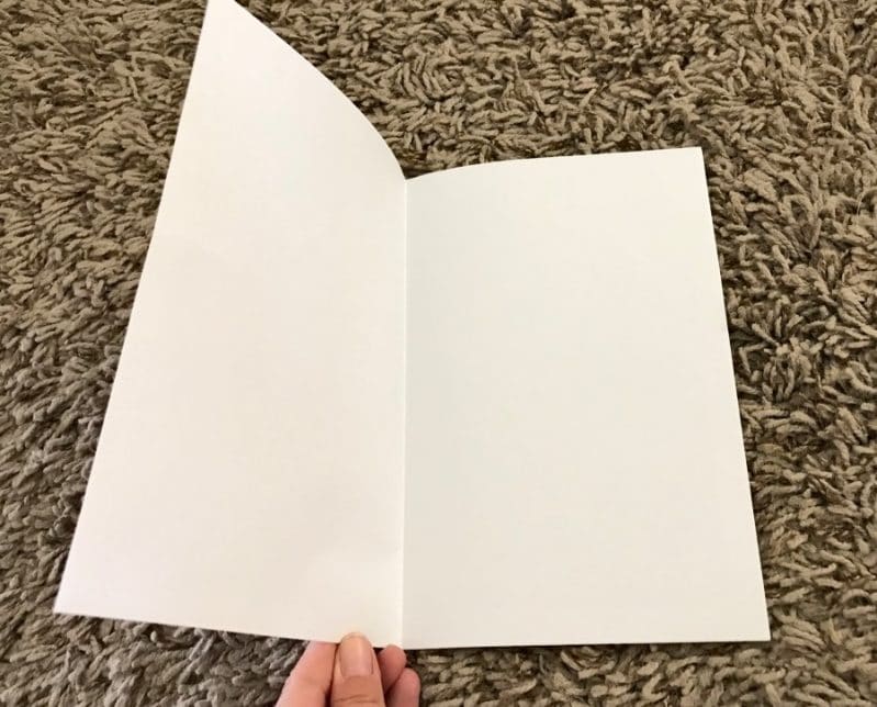 Fold white or lined paper in half to make pages for the travel journal.