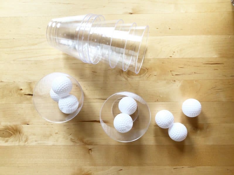 Grab some light weight balls and some cups to set up a fun gross motor challenge for your kids!