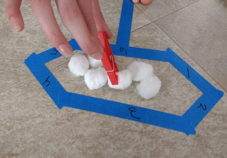 Move cotton balls into each shape using a clothespin
