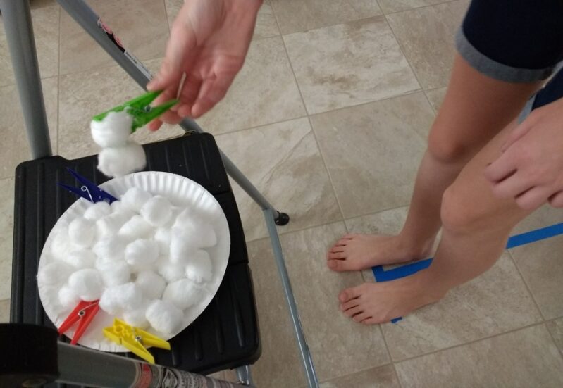 Challenge your kids to the cotton ball transfer activity to work on gross and fine motor skills!