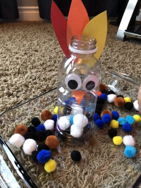 How many pom poms can your child feed the bird? We love this turkey fine motor game!