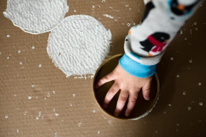 Upcycle a box into a snowman painting project for kids! Stamp down snowballs!