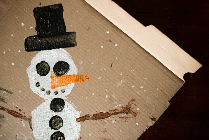 Upcycle a pizza box into a wintery snowman painting project for kids!