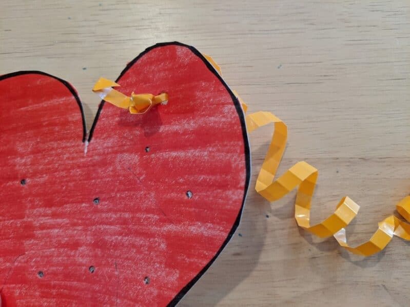 Thread ribbons through the heart for a fun fine motor craft for kids