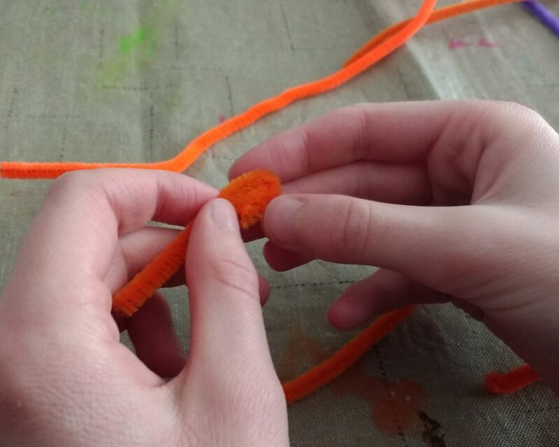 roll a pipe cleaner to make a flower petal