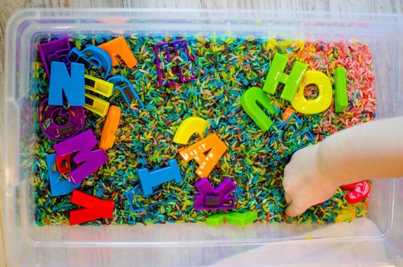 Matching letters in a rainbow rice sensory bin