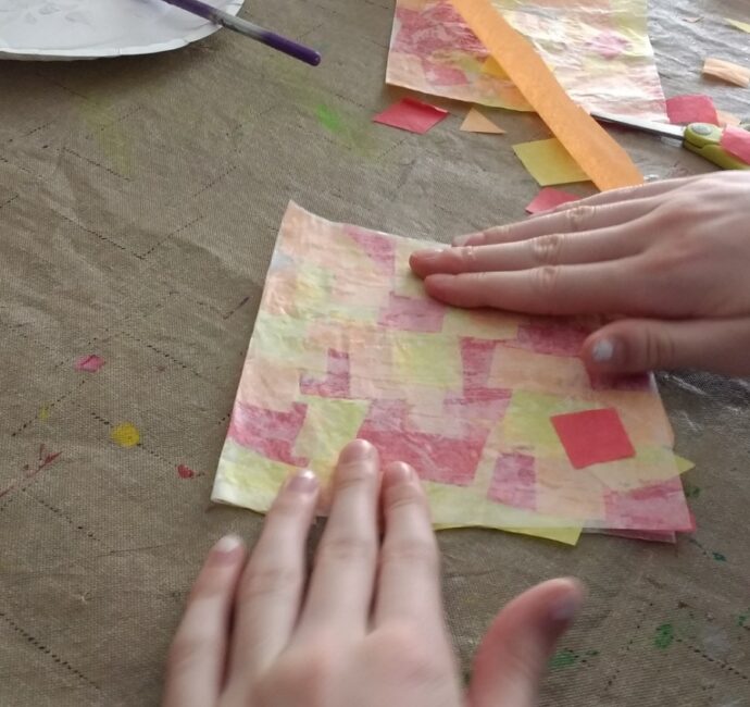 Gluing tissue paper between wax paper for easy fall leaf suncatcher craft for kids.