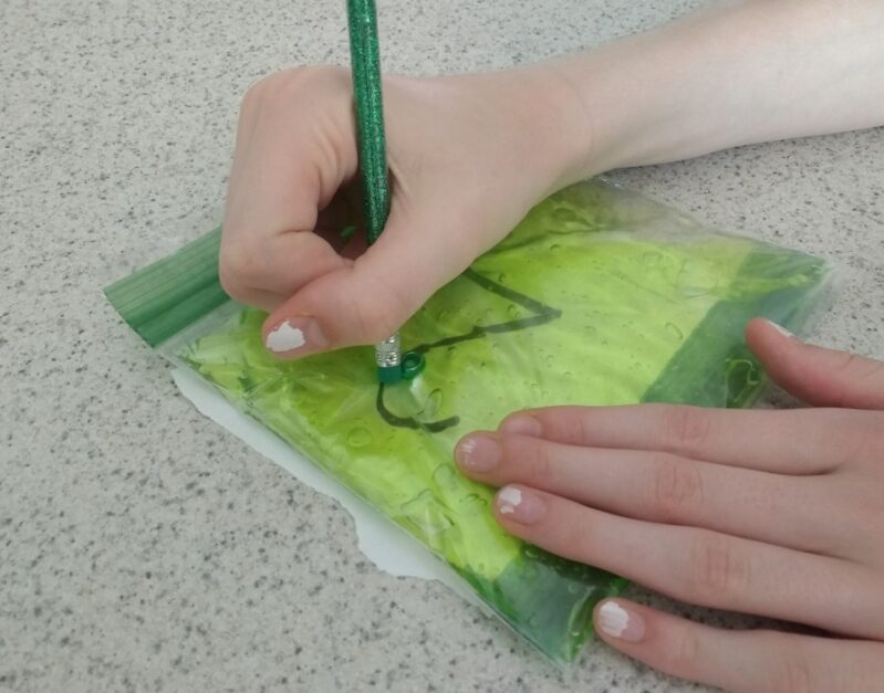 Pushing the bead in the squishy sensory bag along the numbers.