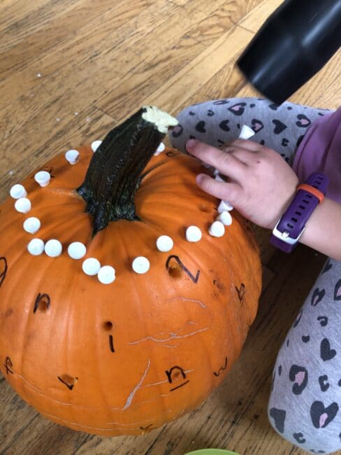 Making a circle pattern on a pumpkin after the activity.