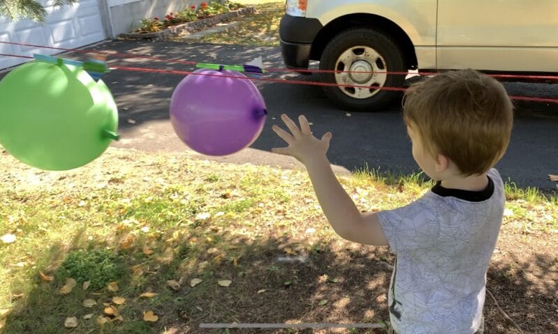 Super simple science experiment with vertical balloon straw rockets to teach kids about Newton’s third law of motion or simply have some fun!