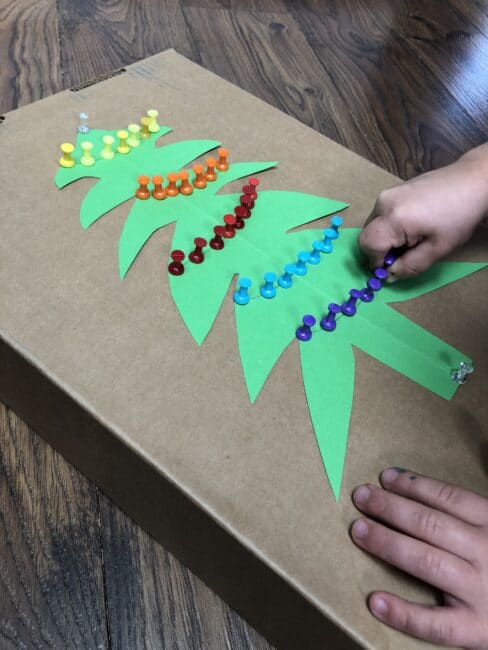 Use push pins to decorate a Christmas tree for fine motor skills and color sorting or patterns with this simple activity.