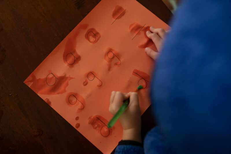 Tracing letters paint with water on construction paper.