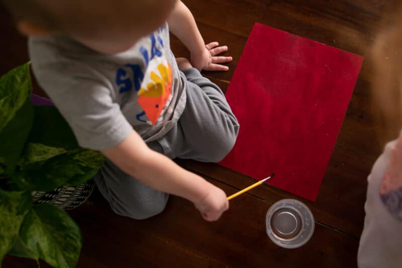 Toddler paint with water to create construction paper art and sensory play activity.