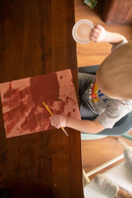 Toddler paint with water to create construction paper art and sensory play activity.