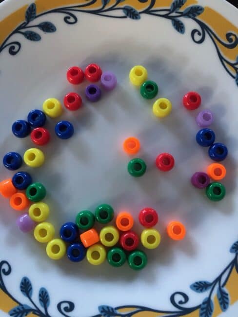 Simple no prep play dough and beads activity for toddlers to learn colors and build fine motor skills using just 2 supplies you have at home.