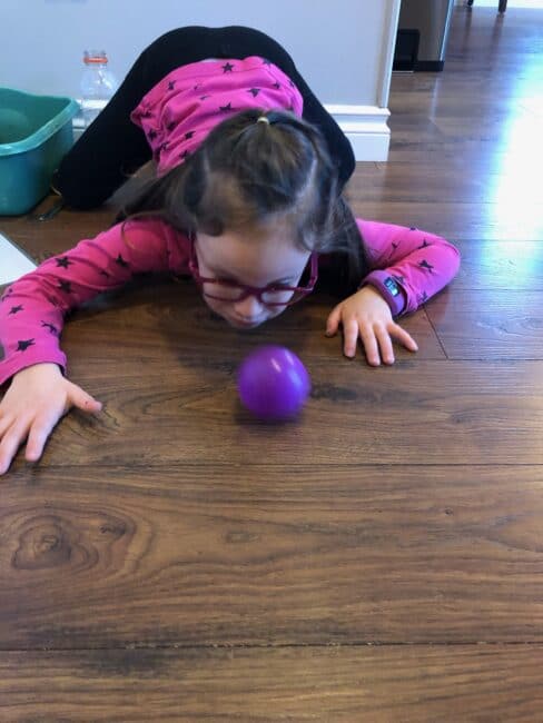 Blowing the ball across the room.