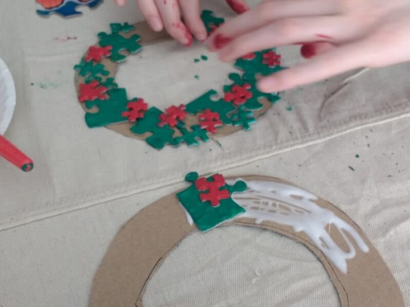 Grab some old puzzle pieces and turn them into a beautiful Christmas wreath craft with this simple activity for toddlers and preschoolers.