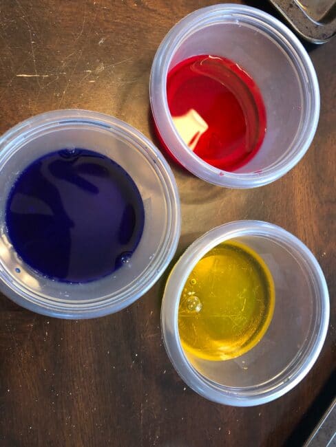 Water and food coloring or watercolors for fine motor color mixing activity.