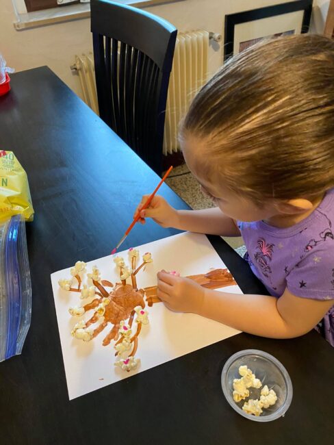 Add dots of pink paint to popcorn to create a cherry blossom spring tree craft with your kids.