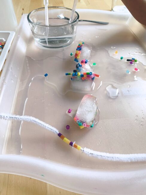 Melting ice and threading beads together in this super simple fine motor activity that’s perfect for preschooler busy play and great to beat the heat!