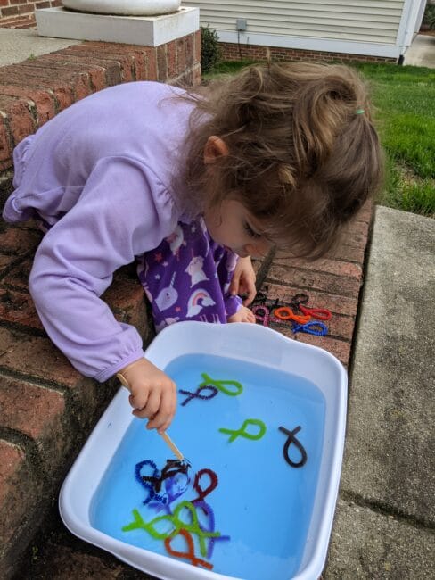 Your toddlers and preschoolers will love this fishing game fine motor activity that is easy to make at home with pipe cleaners, scissors, water and a stick.