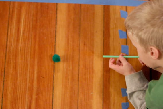 Set up a quick racetrack on the floor and create a fun and easy blowing with straws and pom poms race for your toddlers and preschoolers to improve fine and gross motor skills.