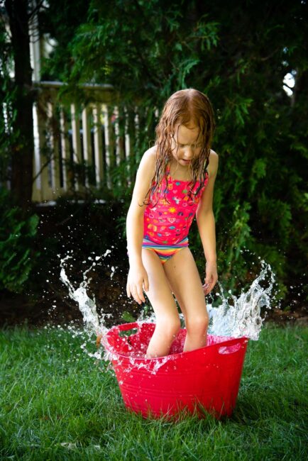 Beat the heat this summer with a simple fun DIY backyard water obstacle course using household supplies for your kids to cool down outside.