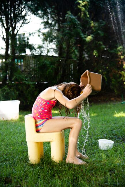 Beat the heat this summer with a simple fun DIY backyard water obstacle course using household supplies for your kids to cool down outside.