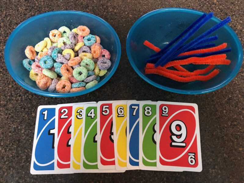 Playing with uno cards and fruit loops is a fine motor, color recognition and counting activity all-in-one!